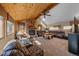 Living room features a stone fireplace, wood beam ceiling and large leather sofa with view at 6080 Kilimanjaro Dr, Evergreen, CO 80439