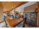 Eat-in kitchen and dining area are adjacent to the living area with stone fireplace and wood beam ceiling at 6080 Kilimanjaro Dr, Evergreen, CO 80439