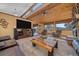 Comfortable living room with wood beam ceiling, ceiling fan, large-screen TV, and many windows with a view at 6080 Kilimanjaro Dr, Evergreen, CO 80439