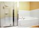 Clean bathroom featuring a shower with a clear glass door and a soaking tub at 8552 Gold Peak Ln # F, Highlands Ranch, CO 80130