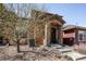 Charming townhome exterior showcasing a stone archway, stone steps, and a shade tree at 8552 Gold Peak Ln # F, Highlands Ranch, CO 80130