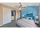 Bright main bedroom with stylish ceiling fan, accent wall, ocean art, and ensuite access at 8552 Gold Peak Ln # F, Highlands Ranch, CO 80130