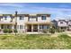 Charming tan two-story townhome with a covered front porch and well-maintained lawn at 16062 E Geddes Dr # 150, Aurora, CO 80016