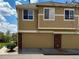 Exterior view showcasing attached two-car garage with brick accents and siding, providing convenient parking at 16062 E Geddes Dr # 150, Aurora, CO 80016