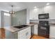 Bright kitchen featuring modern appliances, black sink and range, and stylish light fixture at 16062 E Geddes Dr # 150, Aurora, CO 80016