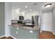 Modern kitchen featuring white cabinetry, stainless steel appliances, and a breakfast bar overlooking living area at 16062 E Geddes Dr # 150, Aurora, CO 80016