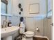 Powder room featuring a pedestal sink, framed mirror, and decorative wall accents for a chic design at 14133 Deertrack Ln, Parker, CO 80134