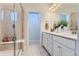 This bathroom features a glass enclosed shower with a bench and a double vanity with framed mirrors at 14133 Deertrack Ln, Parker, CO 80134