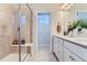 This bathroom features a glass enclosed shower with a bench and a double vanity with framed mirrors at 14133 Deertrack Ln, Parker, CO 80134