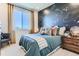 This bedroom features a constellation themed accent wall, a large window, and neutral decor at 14133 Deertrack Ln, Parker, CO 80134