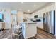Kitchen with white cabinetry, stainless steel appliances, an island with bar stool seating, and wood-look floors at 14133 Deertrack Ln, Parker, CO 80134