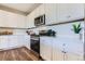 Close-up of the modern kitchen with white cabinets, stainless steel appliances, and subway tile backsplash at 14133 Deertrack Ln, Parker, CO 80134