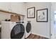 This laundry room has a washer and dryer, white cabinets, and decor at 14133 Deertrack Ln, Parker, CO 80134