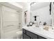 Updated bathroom with modern vanity, large mirror, and shower-tub combination at 1803 E 36Th Ave, Denver, CO 80205