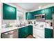 This kitchen features stainless steel appliances, green cabinets and marbled countertops at 1803 E 36Th Ave, Denver, CO 80205
