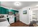 A kitchen featuring stainless steel appliances, green cabinets and wood-look flooring at 1803 E 36Th Ave, Denver, CO 80205