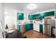 Bright kitchen features green cabinets, stainless steel appliances, and wood-look flooring at 1803 E 36Th Ave, Denver, CO 80205