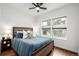 The main bedroom features a ceiling fan, wood-look floors and large windows at 1803 E 36Th Ave, Denver, CO 80205