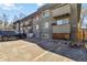 Apartment building with gray exterior, small balconies, and parking spaces, near a wooden fence at 1410 York St # 35, Denver, CO 80206