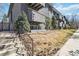 Exterior view of a grey apartment building with small balconies, landscaping, and concrete stairs leading to the units at 1410 York St # 35, Denver, CO 80206