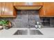 Close-up of kitchen sink area with stylish faucet, tile backsplash, and decorative elements at 1410 York St # 35, Denver, CO 80206