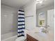 Bathroom featuring a shower-tub combo with blue striped curtain, a wood cabinet and marble countertop at 6877 Northstar Ct, Castle Rock, CO 80108