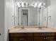 Bathroom with a double sink vanity, dark wood cabinets, and warm lighting at 6877 Northstar Ct, Castle Rock, CO 80108