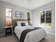 Sunlit bedroom with a woven headboard, neutral walls, and large windows at 6877 Northstar Ct, Castle Rock, CO 80108