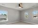 Vacant bedroom with neutral walls, light carpet, ceiling fan, and bright natural light from three windows at 6877 Northstar Ct, Castle Rock, CO 80108