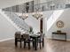Sunlit dining area featuring high ceilings, elegant chandeliers, and a view of the open staircase at 6877 Northstar Ct, Castle Rock, CO 80108