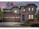 Elegant home featuring a stone facade, three-car garage, and beautiful architectural details at dusk at 6877 Northstar Ct, Castle Rock, CO 80108