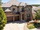 This stunning home has a 3-car garage, stone accents, a tile roof, and a long concrete driveway at 6877 Northstar Ct, Castle Rock, CO 80108