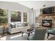 Bright living room featuring a stone fireplace, large windows, and comfortable seating at 6877 Northstar Ct, Castle Rock, CO 80108