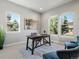 Bright office space with a dark wood desk, three windows, neutral walls, and a light carpet at 6877 Northstar Ct, Castle Rock, CO 80108
