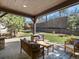 Beautiful outdoor patio with a stone fireplace, comfortable seating and a lush landscaped backyard view at 6877 Northstar Ct, Castle Rock, CO 80108