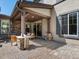 Inviting covered patio features stone pillars, pavers, and comfortable seating, perfect for outdoor relaxation at 6877 Northstar Ct, Castle Rock, CO 80108