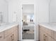 Bathroom with double vanities leading into a bedroom filled with natural light at 8711 E Hampden Ave # 20, Denver, CO 80231