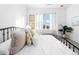 Bright bedroom with a large window, light colored pillows, and decorative floral art at 8711 E Hampden Ave # 20, Denver, CO 80231