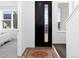 Inviting entryway with a black door, patterned rug, and views into a bright bedroom at 8711 E Hampden Ave # 20, Denver, CO 80231