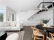 Open-concept living space with modern light fixture, sleek furniture, and staircase, creating a sophisticated and inviting atmosphere at 8711 E Hampden Ave # 20, Denver, CO 80231