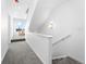 Bright hallway with a carpeted floor and staircase leading to the upper floors of the home at 8711 E Hampden Ave # 20, Denver, CO 80231