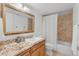 Bathroom featuring a vanity with granite countertops, a decorative mirror, and a shower with tile surround at 11702 Perry St, Westminster, CO 80031