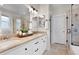 Bright bathroom features a double vanity, stone countertops, dual mirrors, and tiled shower at 11702 Perry St, Westminster, CO 80031