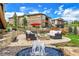 Beautiful backyard with a stone patio, comfortable seating around a fire pit, and fountain feature at 5388 Water Oak Cir, Castle Rock, CO 80108