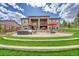 Landscaped backyard featuring a tiered patio, outdoor seating, and lush green lawn at 5388 Water Oak Cir, Castle Rock, CO 80108