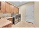 Laundry room features tile floors, counter space with sink, and modern washer and dryer units at 5388 Water Oak Cir, Castle Rock, CO 80108