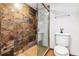 Bathroom featuring stone tiled shower and toilet with ceramic tile flooring at 1551 Larimer St # 1803, Denver, CO 80202