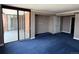 Carpeted bedroom with sliding glass doors to a balcony, a walk-in closet, and neutral-toned walls at 1551 Larimer St # 1803, Denver, CO 80202