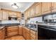Well-lit kitchen showcasing wood cabinetry, granite countertops, stainless steel appliances, and a modern sink at 1551 Larimer St # 1803, Denver, CO 80202