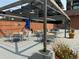 Outdoor patio under pergola with tables, chairs, and potted flowers at 1551 Larimer St # 1803, Denver, CO 80202